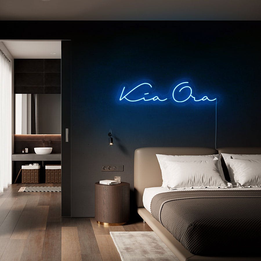 Blue neon sign over bed reads kia ora