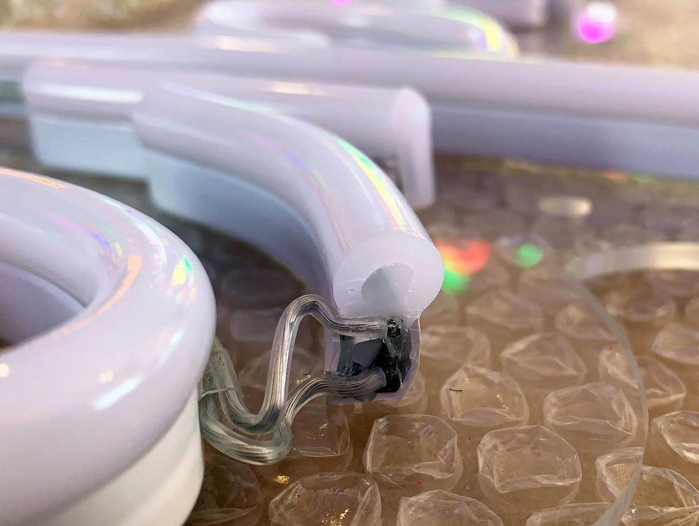 an LED neon light’s pin connection being repaired