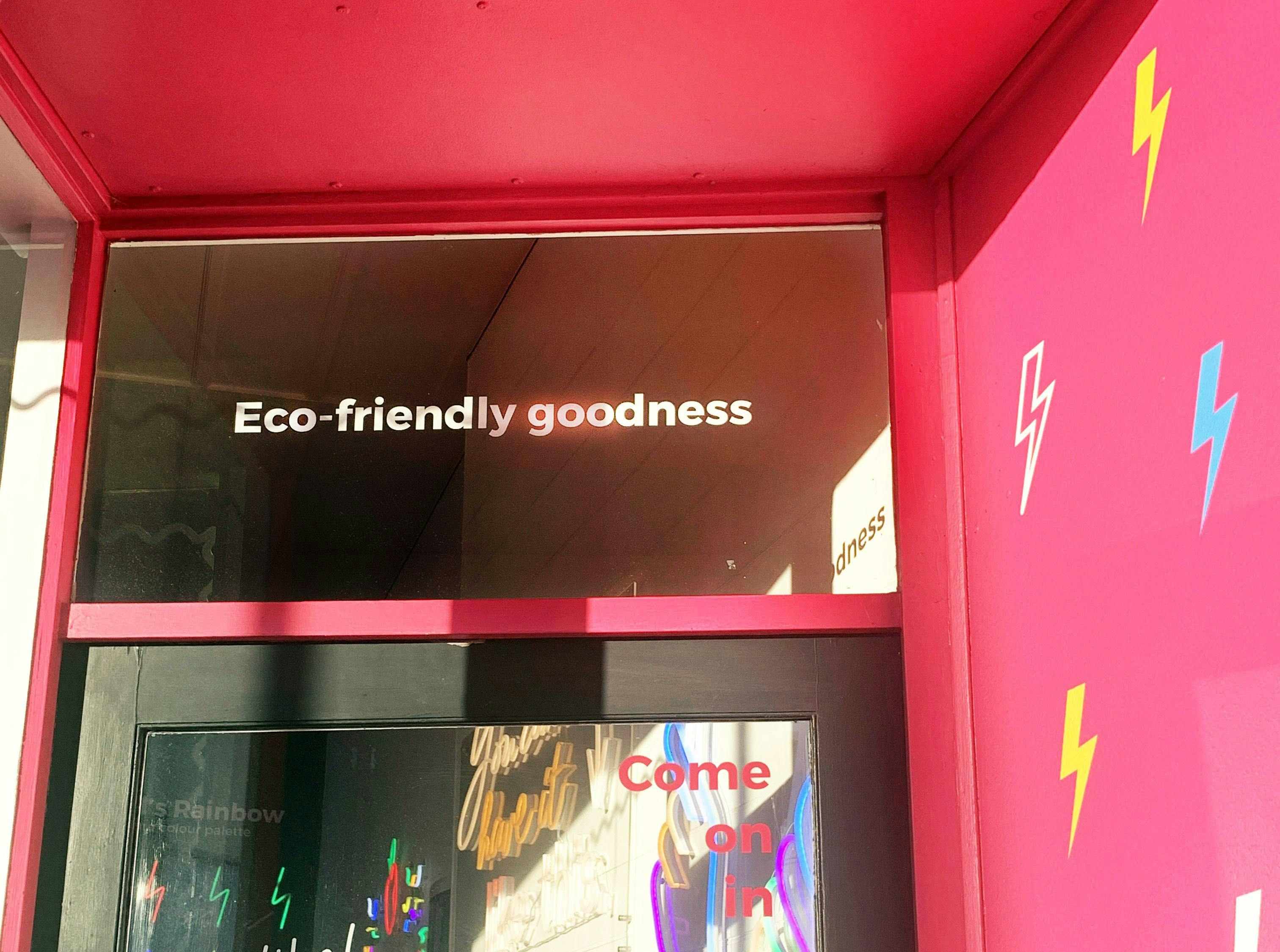 a neon sign at a store saying ‘Eco-friendly goodness’