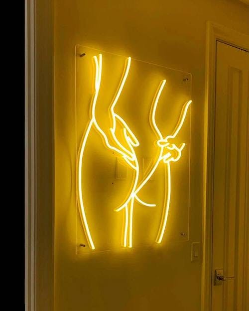a personalized naughty neon sign with woman adjusting bathing suit