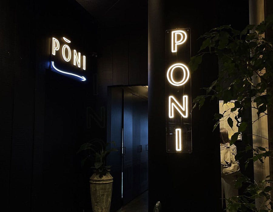 two storefront neon signs that say “poni”