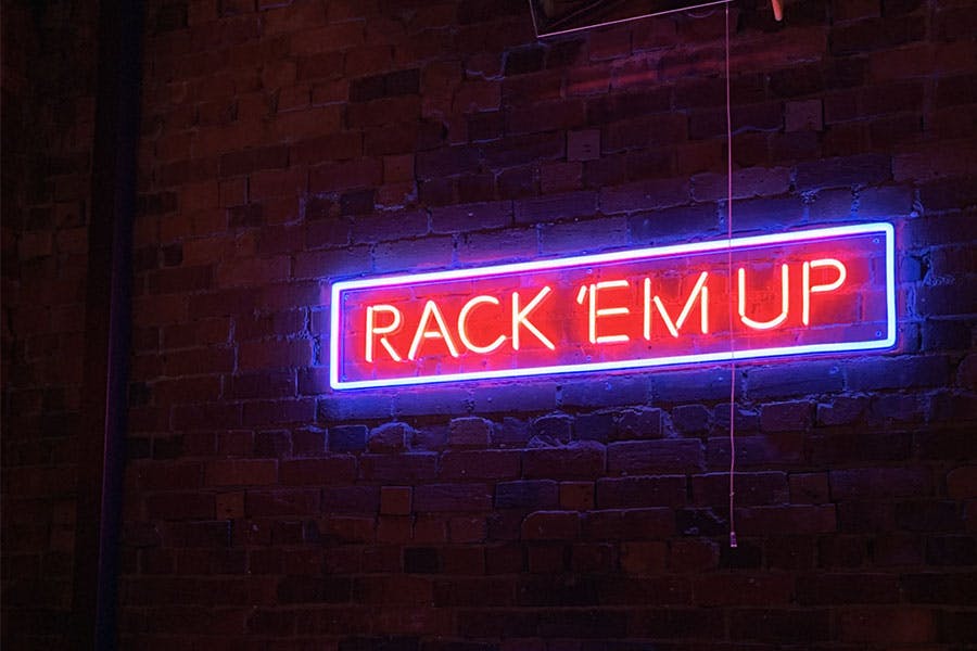 red neon sign reading rack em up in a blue rectangle