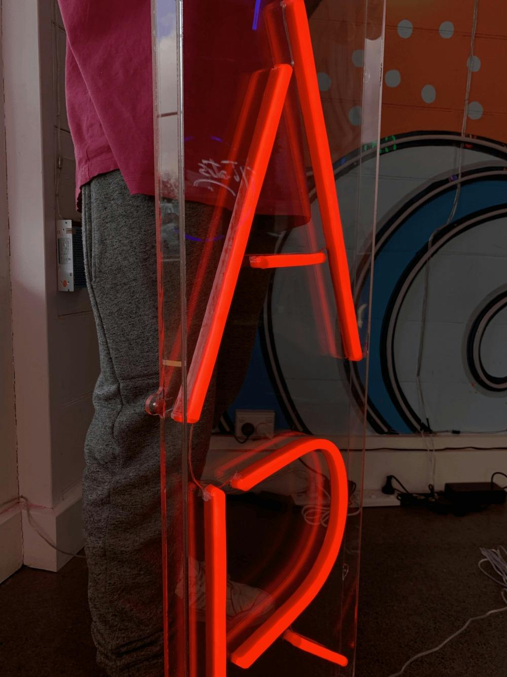 a side angle view of an outdoor neon sign in an acrylic box