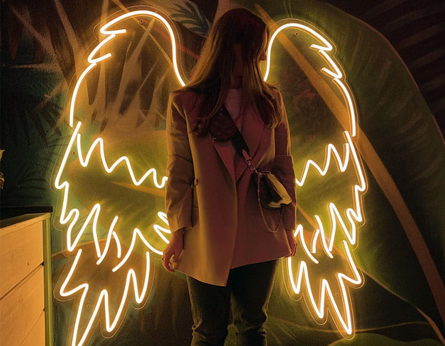 woman standing in front of angel wings